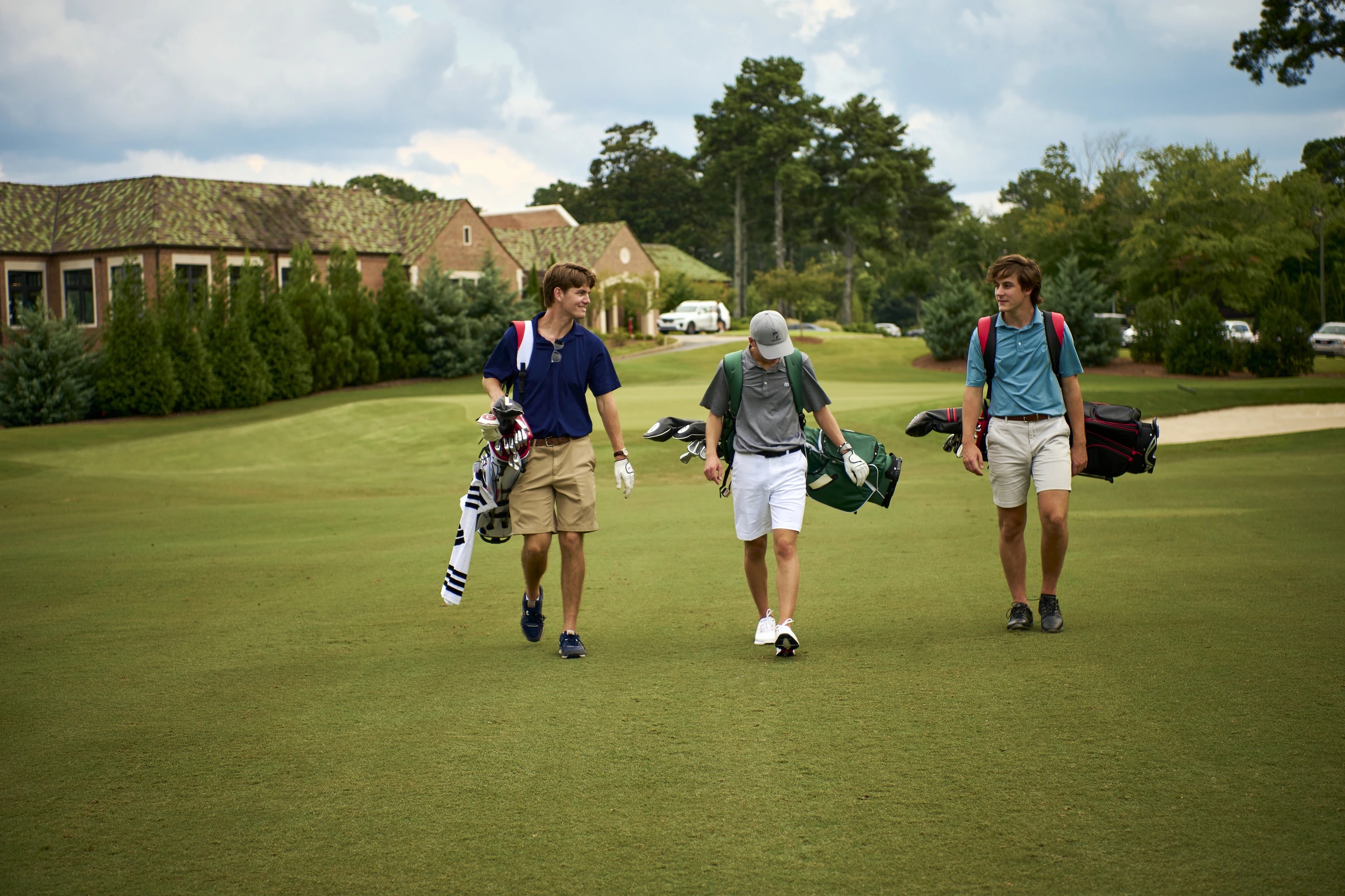 Three golfers walking the fairway with JCR bags
